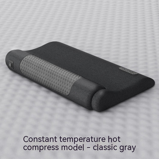 Dark gray cervical spine pillow with light gray textured massage area and power button on a light gray surface. - Image 5