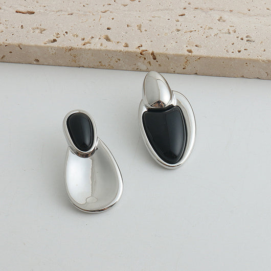Pair of gold-toned irregular earrings with black onyx-like inserts, featuring a modern, abstract design. - Image 9