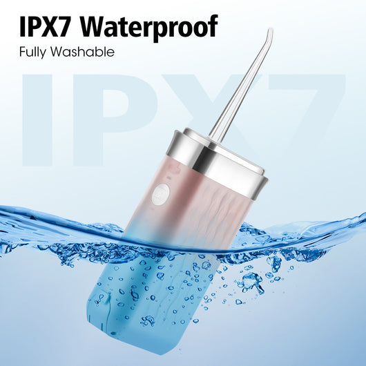 Portable water flosser in gradient pink and blue with four nozzles, a charging cable, and its product box. - Image 23