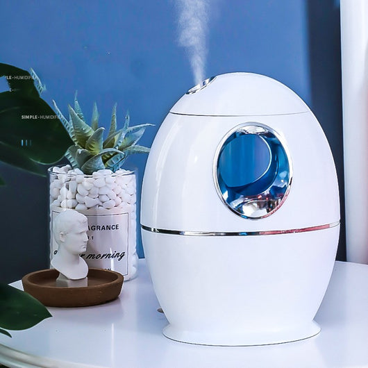 White egg-shaped household humidifier with a blue-lit circular opening and silver trim. - Image 9