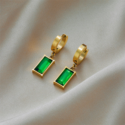 Gold hoop earrings with rectangular emerald green zircon pendants, displayed on a light beige fabric. - Image 11
