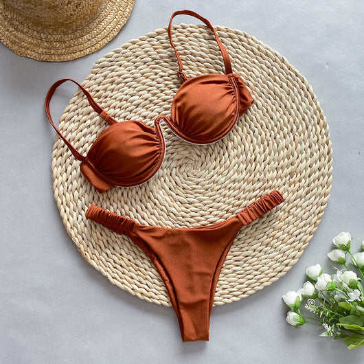 Rust underwire bikini set with ruched top and high-cut bottom, displayed on a woven mat. - Image 3
