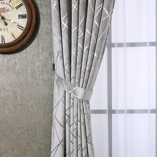 Gray chenille blackout curtains with a subtle silver geometric pattern, hung on a gold rod in a modern living room. - Image 6