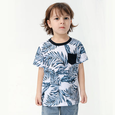 Young boy wearing a white short-sleeve t-shirt with blue tropical leaf print and a black chest pocket. - Image 15