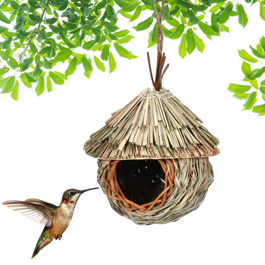 Handmade hanging bird nest crafted from natural grass and wicker, featuring a thatched roof and a round entrance.