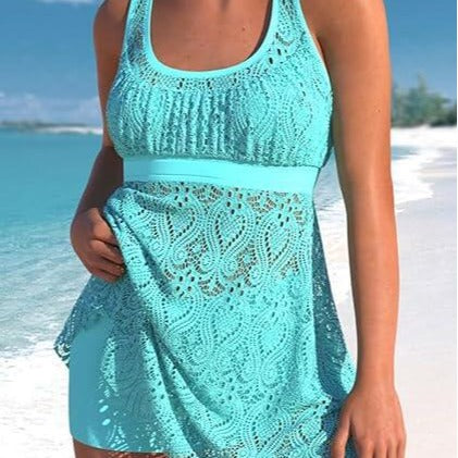Women's turquoise two-piece swimwear set with a crochet tankini top and matching swim shorts on a beach.