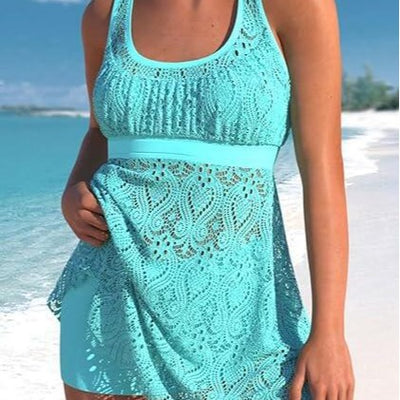 Women's turquoise two-piece swimwear set with a crochet tankini top and matching swim shorts on a beach.
