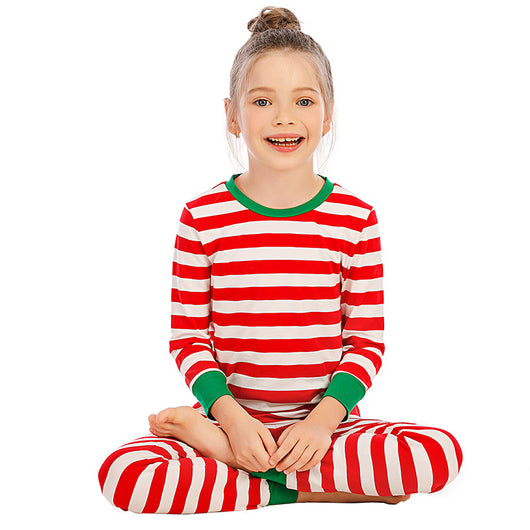 Girl wearing red and white striped long-sleeved pajamas with green trim on collar and cuffs. - Image 4