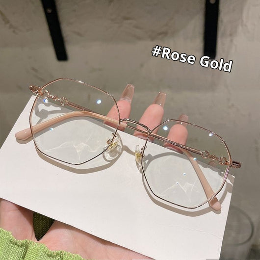 Rose gold frameless polygon anti-blue light glasses with clear lenses, held by a hand with pink nails. - Image 6