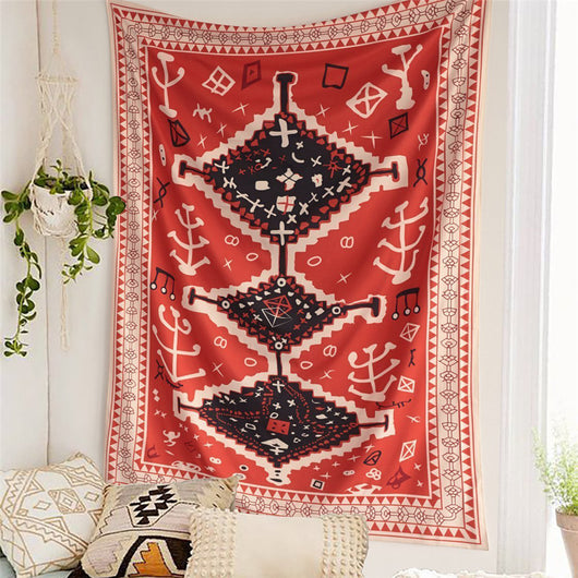 Red tapestry with black and white geometric tribal pattern hanging on a white wall above decorative pillows. - Image 8