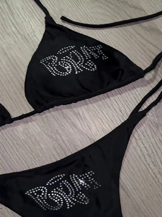 Black halter bikini with rhinestone 'BRAT' lettering on triangle top and tie-side bottom, displayed on white faux fur. - Image 14