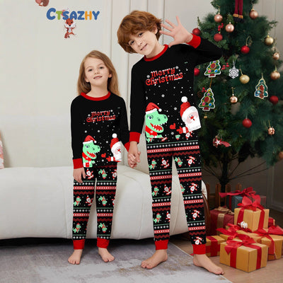 Man wearing black Christmas pajamas with a cartoon dinosaur, Santa Claus, and "Merry Christmas" text, standing by a decorated tree. - Image 2