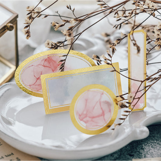 Assorted decorative paper labels with gold foil borders and soft watercolor designs in pink, blue, and green hues. - Image 6