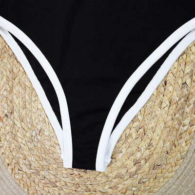 Woman in a white one-piece swimsuit with black trim and decorative buttons, sitting on a boat. - Image 23