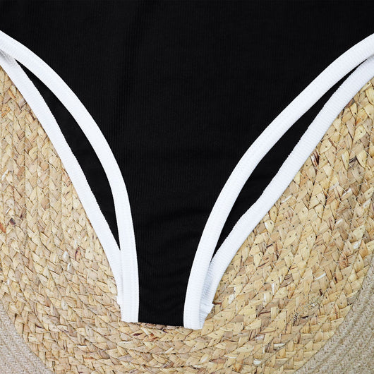 Woman in a white one-piece swimsuit with black trim and decorative buttons, sitting on a boat. - Image 23