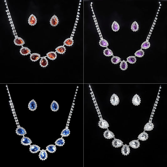 Purple teardrop rhinestone necklace and matching stud earrings set on a black background.