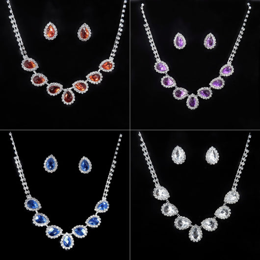 Purple teardrop rhinestone necklace and matching stud earrings set on a black background.