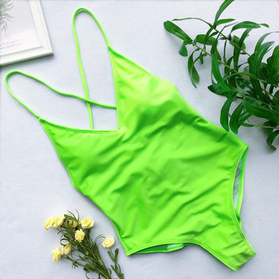Light blue backless one-piece swimsuit with thin straps, made of polyester, laid flat on a wooden surface. - Image 11