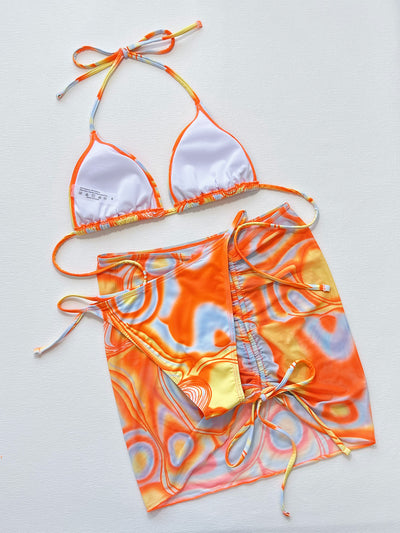 Women's three-piece swimsuit with orange, yellow, and blue abstract swirl pattern. Includes a triangle bikini top, tie-side bottom, and matching ruched sarong s - Image 12