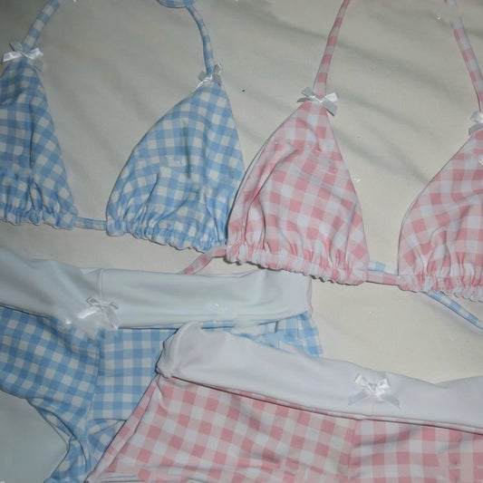 Red and white gingham high-waisted bikini set with triangle top, laid on sand under sunlight. - Image 2