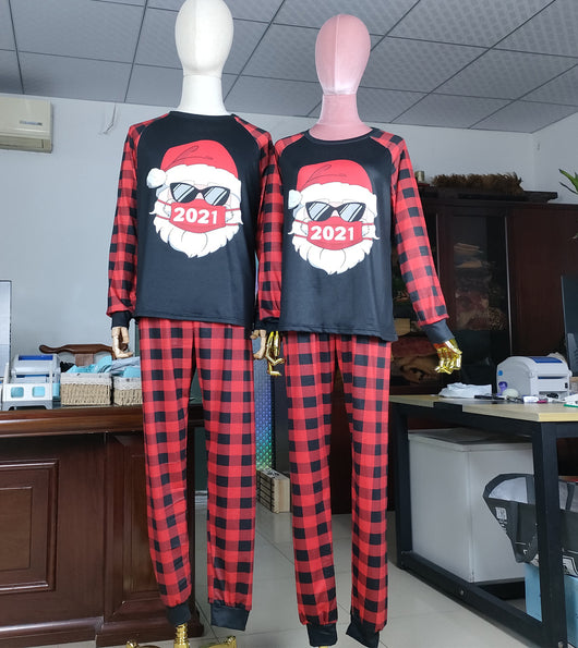 Family matching Christmas pajamas with a Santa Claus graphic wearing sunglasses and a '2021' mask, paired with red and black buffalo plaid pants. - Image 3