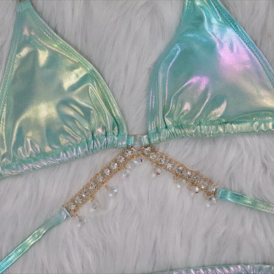 Iridescent purple and pink two-piece bikini with gold-toned crystal embellishments on a white faux fur background. - Image 14