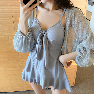 Women's light blue one-piece swimsuit with tie-front bust and ruffled hem, paired with a sheer shimmery cover-up. - Image 4