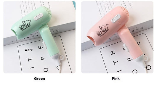 Light blue foldable hair dryer with a cartoon pig design, white power switch, and hanging loop. - Image 13