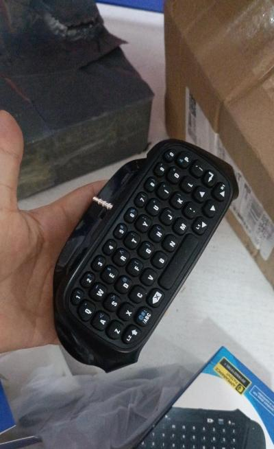 Black wireless keyboard attachment for PS4 game controller, featuring a full QWERTY layout and 3.5mm audio jack. - Image 7