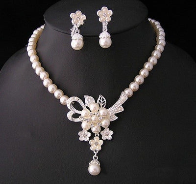 Three-piece pearl jewelry set with multi-strand necklace, bracelet, and drop earrings, all featuring sparkling rhinestone flower accents. - Image 6