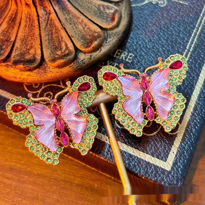 Pink enamel butterfly brooch with green, red, and clear rhinestones set in gold-toned metal. - Image 4