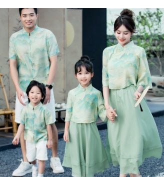 Mother and daughter in matching light green Chinese style cheongsam suits with patterned tops and solid skirts. - Image 15