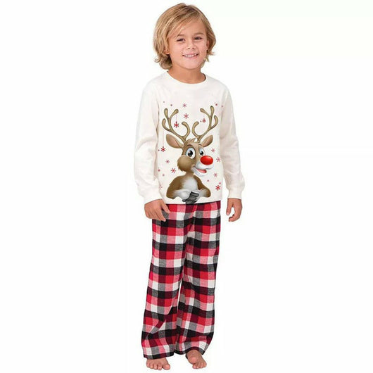 Family of four and a golden retriever wearing matching white long-sleeve reindeer tops and red plaid pajama pants. - Image 2