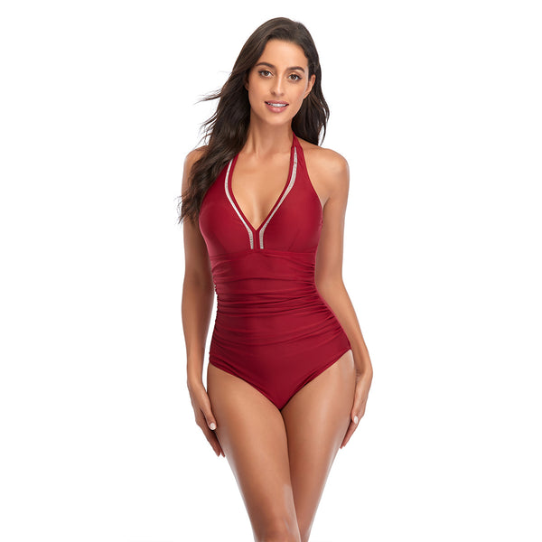 Woman wearing a red halterneck one-piece swimsuit with a V-neckline and ruched detailing on the torso.