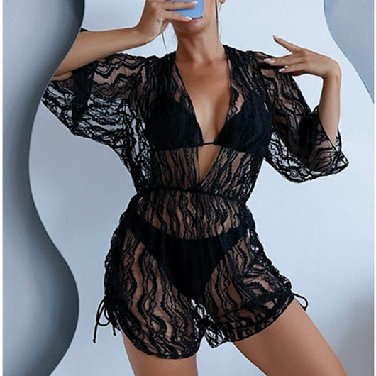 Woman wearing a white and black tie-dye beach cover-up romper with a deep V-neck and drawstring sides. - Image 16