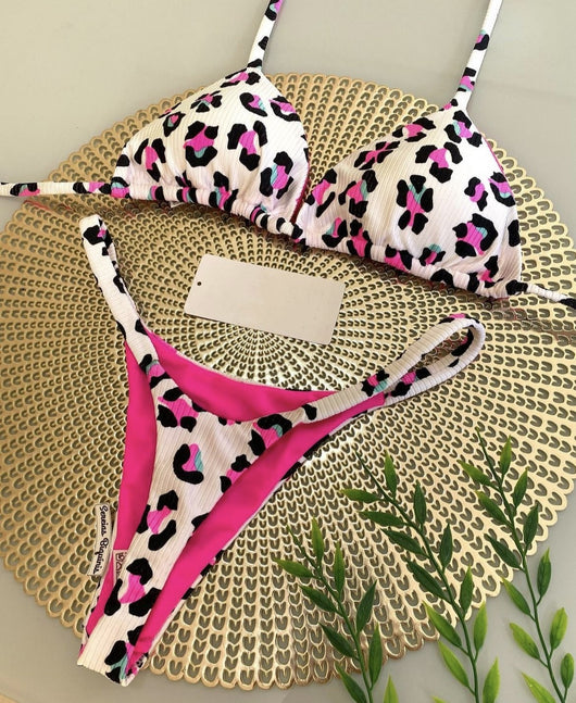 White textured bikini with red cherry print, featuring a triangle top and tie-side bottoms, on a woven mat. - Image 6