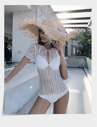 White lace cut-out one-piece swimsuit with short sleeves and a deep V-neckline, modeled by a woman. - Image 12