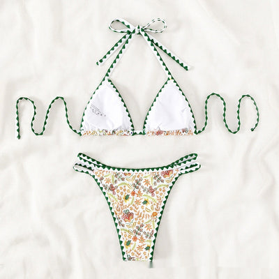 White halter bikini with green rickrack trim and a vibrant floral and bird print, featuring a triangle top and high-cut bottom. - Image 2