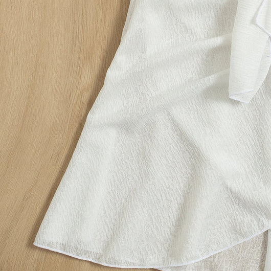 White two-piece swimwear set with a tie-front crop top and a high-waisted skirt with an asymmetrical ruffled hem. - Image 9