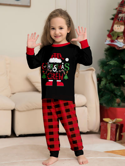 Man wearing black and red plaid Christmas pajamas with a Santa graphic top and matching pants. - Image 2