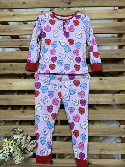 Pink long-sleeve pajama set with a conversation heart print, red Henley neckline, and matching full-length pants. - Image 15