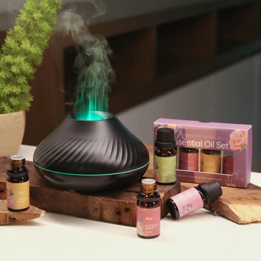 Black flame aromatherapy diffuser with purple mist and four essential oil bottles: Lily, Rose, Sakura, and Lemon. - Image 3