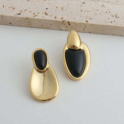 Pair of gold-toned irregular earrings with black onyx-like inserts, featuring a modern, abstract design. - Image 27
