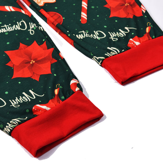 Green baby Christmas pajama romper with red trim, featuring candy canes, ornaments, gingerbread men, and poinsettias. - Image 5