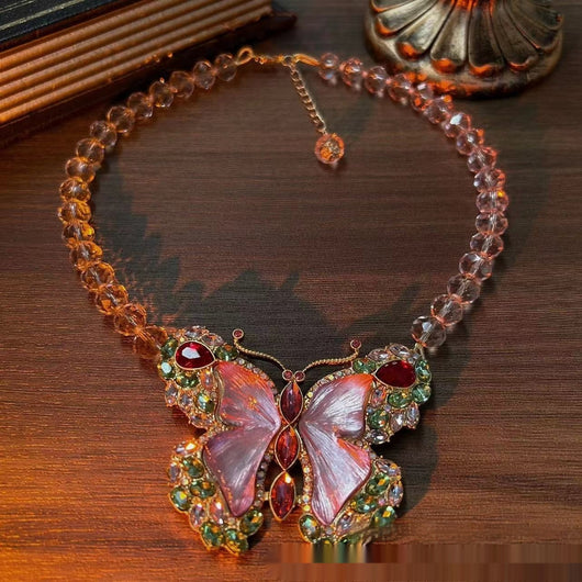 Pink enamel butterfly brooch with green, red, and clear rhinestones set in gold-toned metal. - Image 8