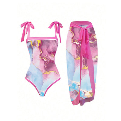 Women's one-piece swimsuit and matching sarong with a pink, blue, and gold marble print. Features tie-shoulder straps.