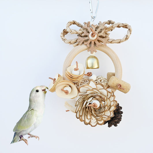 Natural wood and plant fiber bird toy with a ring, pine cones, wood slices, rattan balls, a bell, and a metal clip.