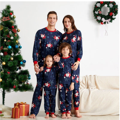 Family of four wearing matching navy blue Christmas pajamas with Santa Claus and snowflake print, red trim. - Image 11