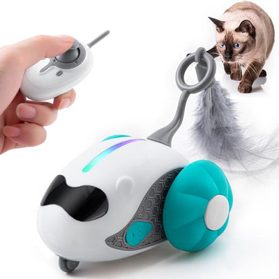 Interactive cat toy with white robotic base, orange wheels, and feather attachment, controlled by a remote, with a cat looking on.