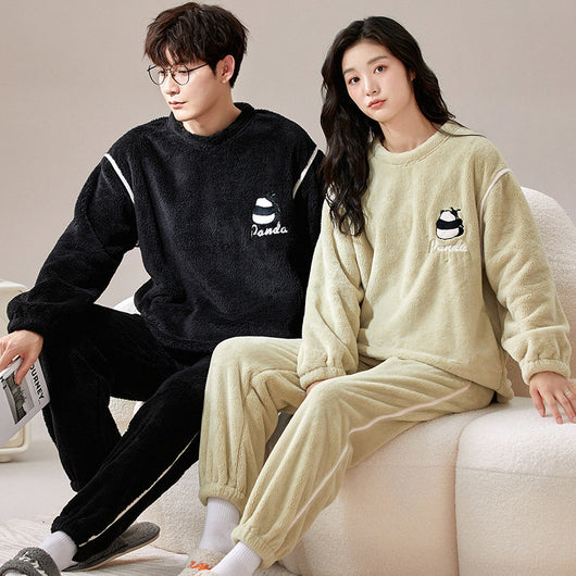 Couple wearing matching cream coral fleece pajamas with gray pants and bear embroidery, seated on a bed. - Image 12